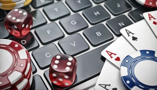 cards, dice, and poker chips on a laptop keyboard